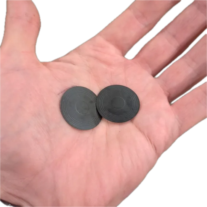 Two repeater stickers held in an open palm, each a thin dark disc