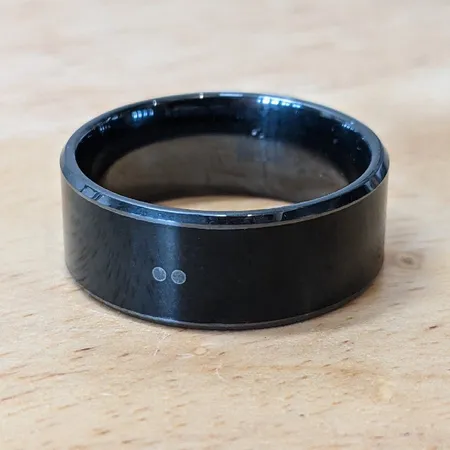Magic Ring on a wooden surface, its two chip-position marker dots visible on the band