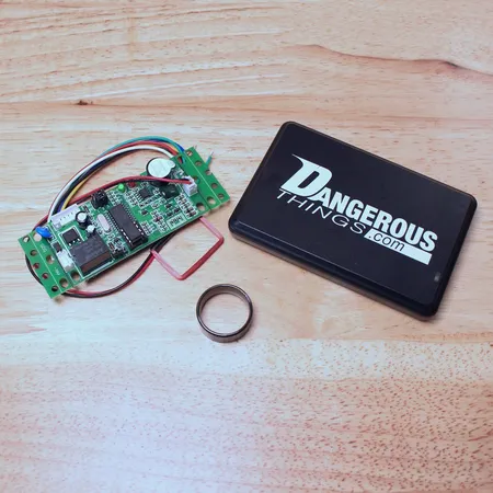 Magic Ring beside a Dangerous Things reader and an open RFID reader board on a workbench