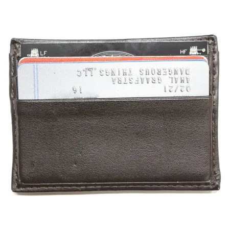 RFID Diagnostic Card in a brown leather card wallet, its LF and HF indicators showing at the top edge