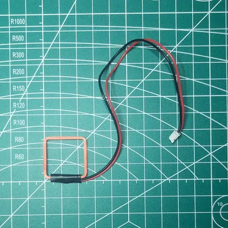 xEM Access Controller antenna coil and its two-wire lead on a measurement mat